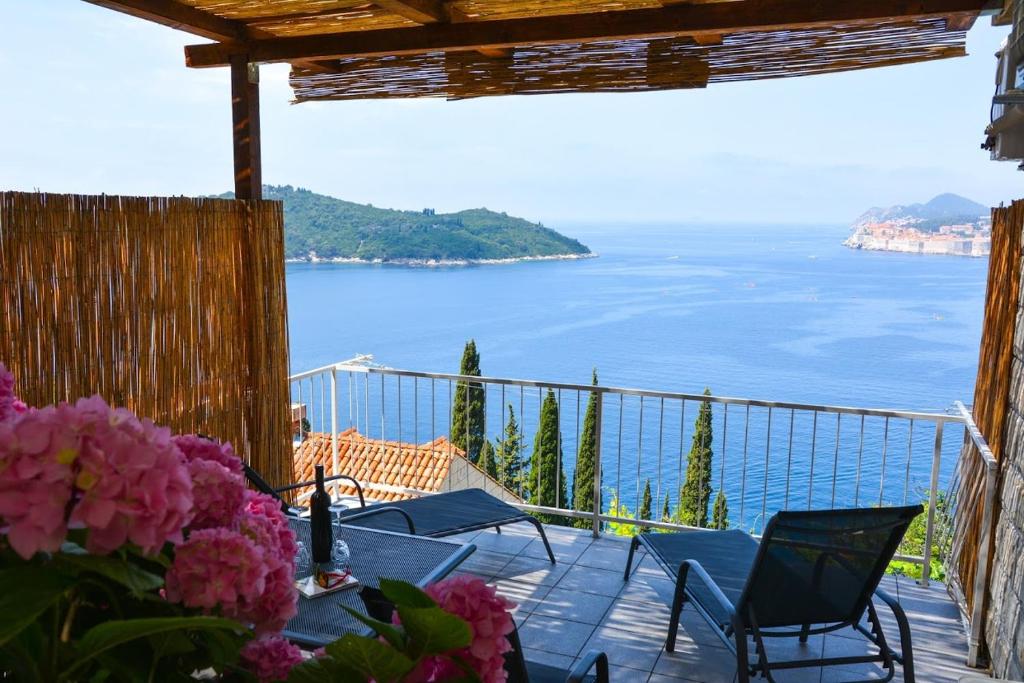 a balcony with tables and chairs and a view of the ocean at Apartment and room Sveti Jakov in Dubrovnik
