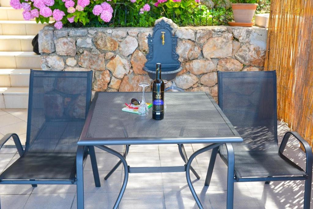 a table with a bottle of wine and two chairs at Apartment and room Sveti Jakov in Dubrovnik