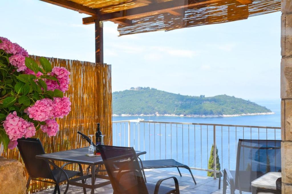 a table and chairs on a balcony with a view of the ocean at Apartment and room Sveti Jakov in Dubrovnik