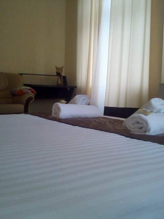 a bedroom with two beds with white sheets and curtains at Smile Khreschatyk Kyiv in Kyiv