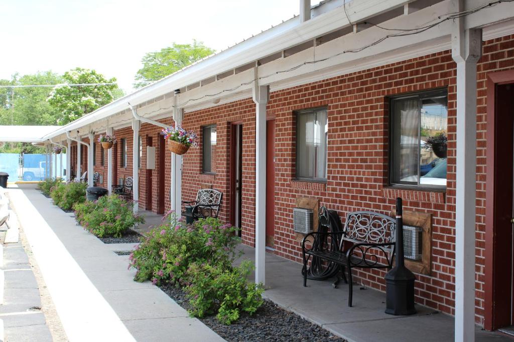 een bakstenen gebouw met banken aan de zijkant bij Ontario Inn in Ontario