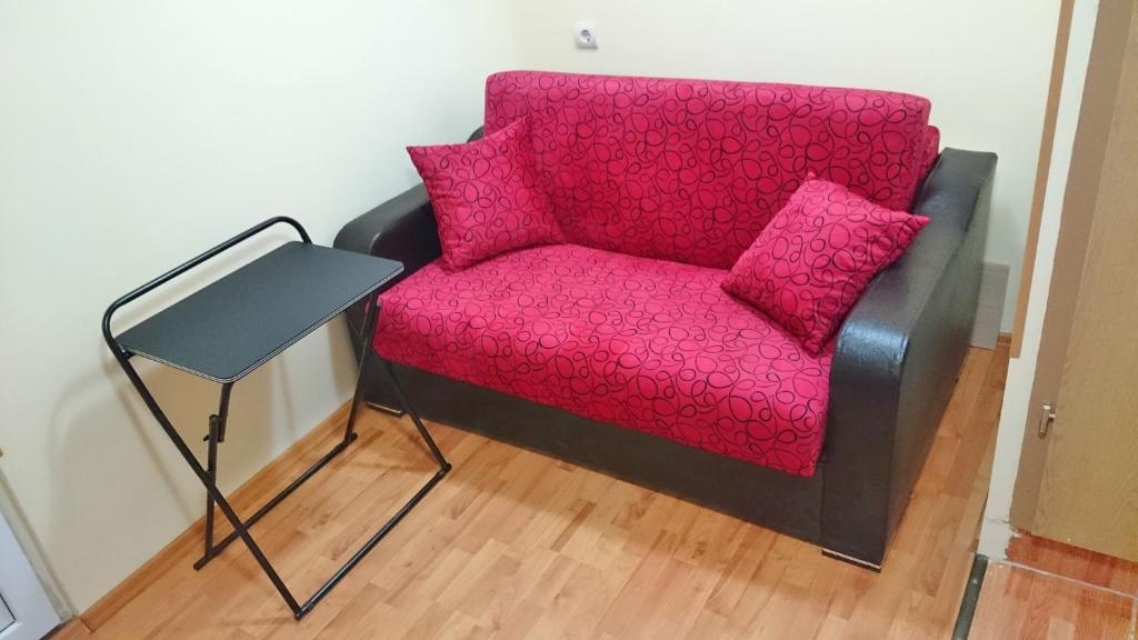 クルジュ・ナポカにあるMiniStudio UltraCentralの赤い椅子(テーブルの横にピンクの枕付)