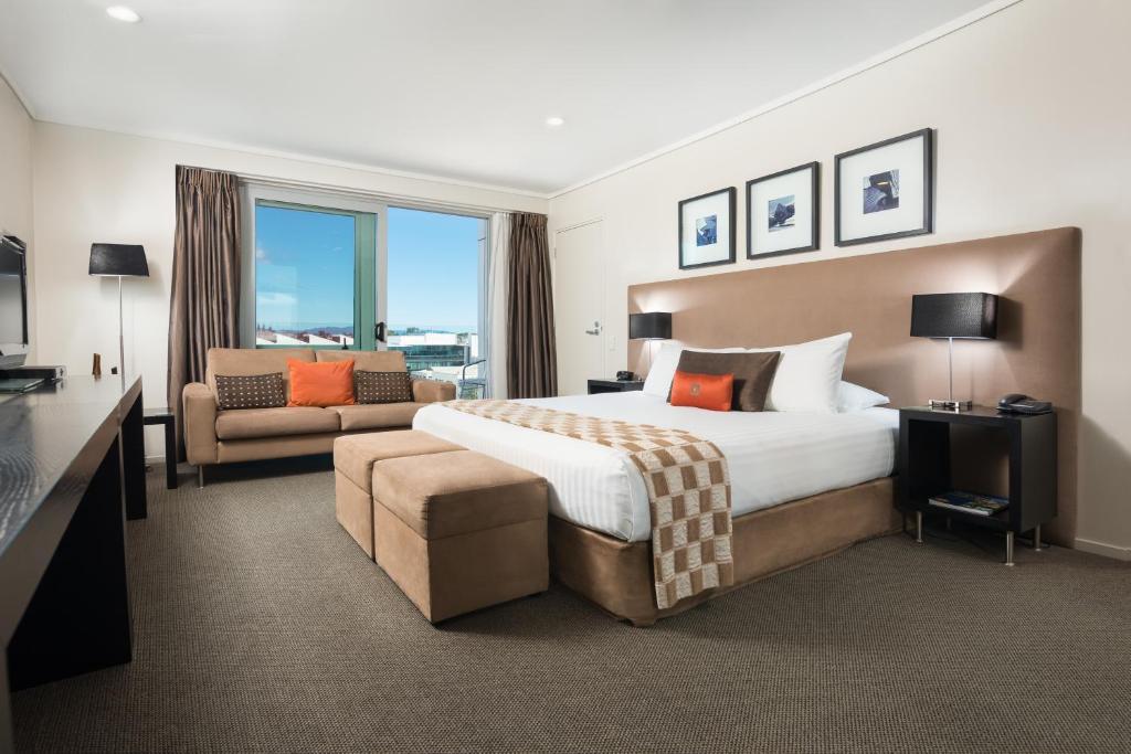 a hotel room with two beds and a television at Hotel on Devonport in Tauranga