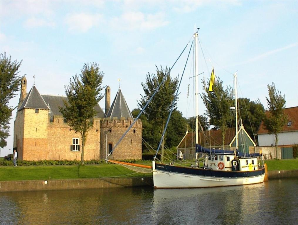 ein Boot vor einem Schloss angedockt ist in der Unterkunft Zeilschip Fortuna in Medemblik