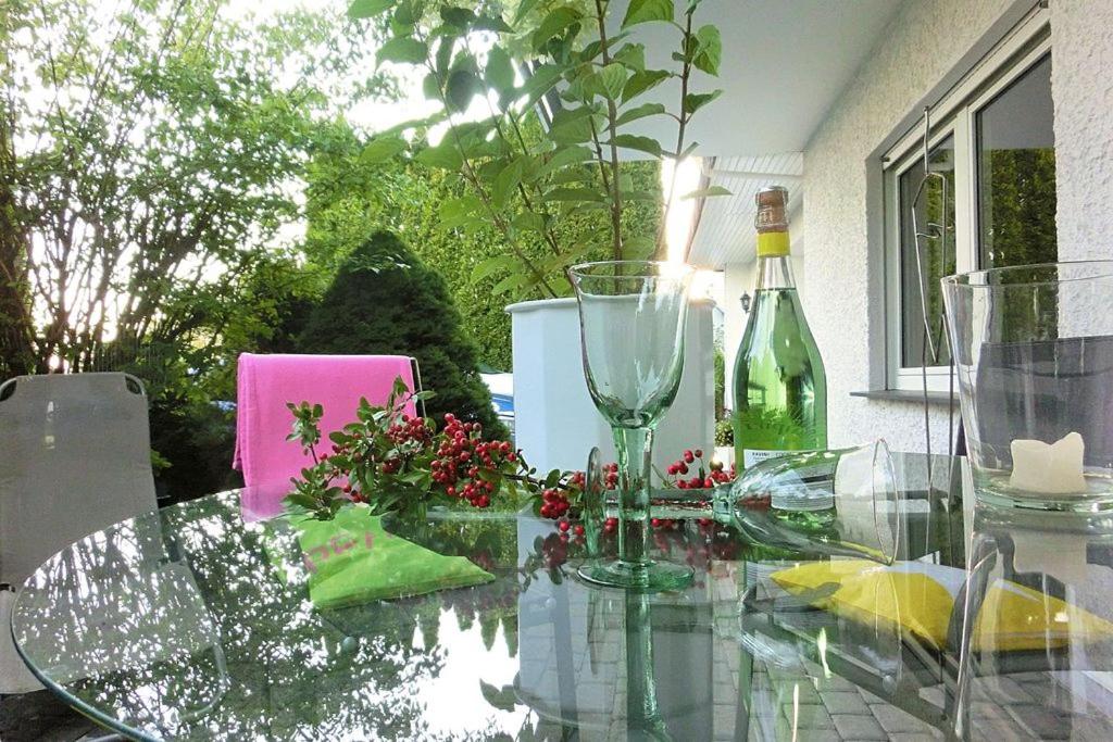uma mesa de vidro com uma garrafa de vinho e flores em Ambiente em Homberg