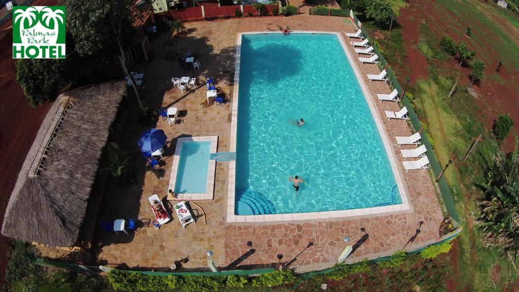 an overhead view of a large swimming pool with people in it at Palmas Park Hotel y Restaurant in Obligado