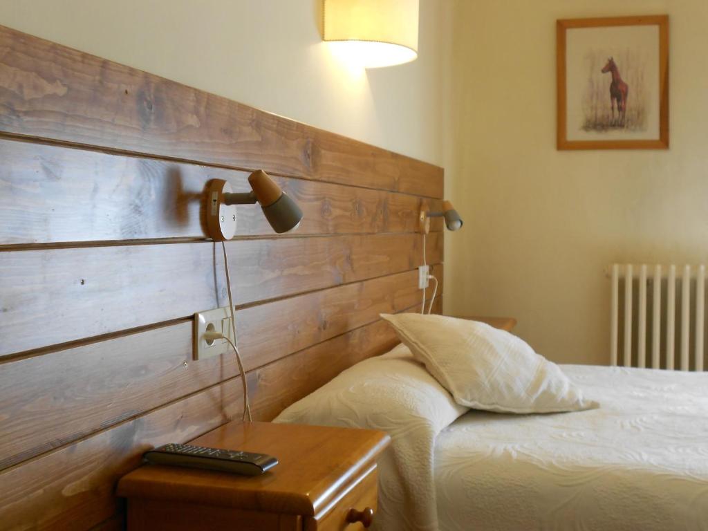 a bedroom with a bed and a lamp on a table at Hostal La Catalana in Sant Llorenc de Morunys