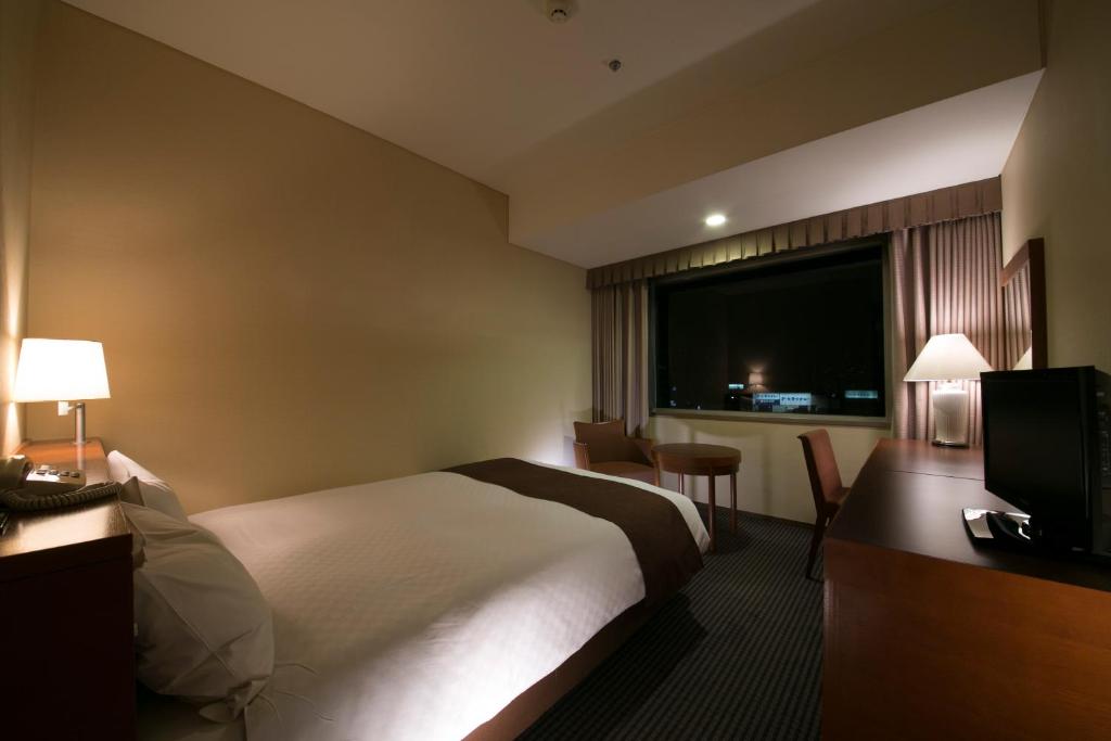 Postel nebo postele na pokoji v ubytování Meitetsu Grand Hotel