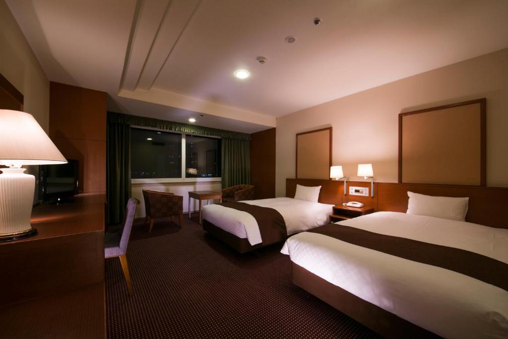Postel nebo postele na pokoji v ubytování Meitetsu Grand Hotel