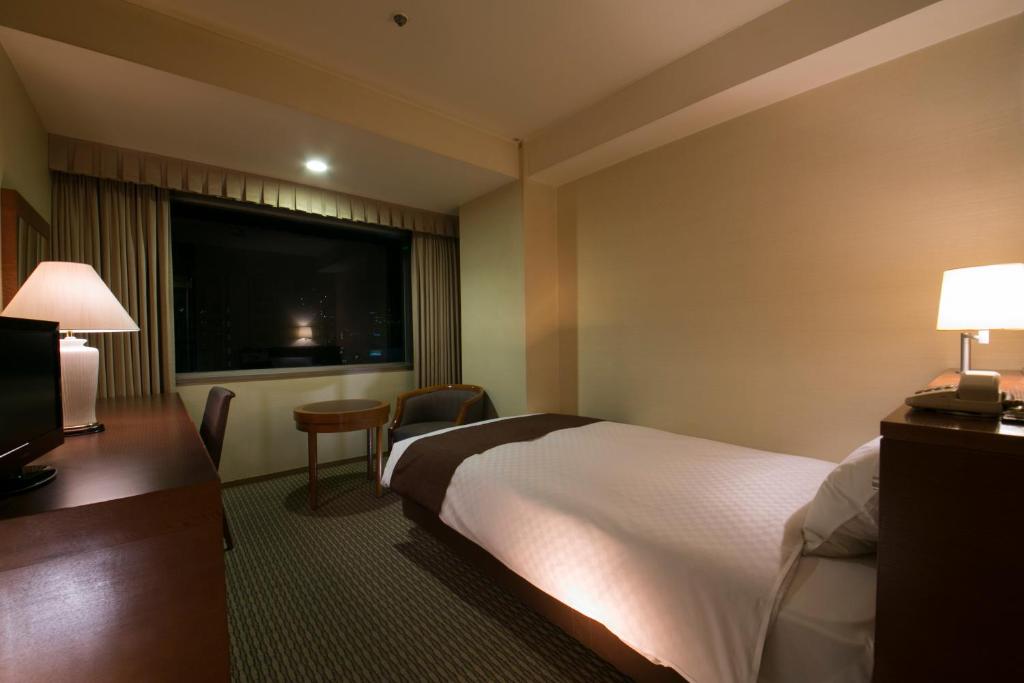 Postel nebo postele na pokoji v ubytování Meitetsu Grand Hotel