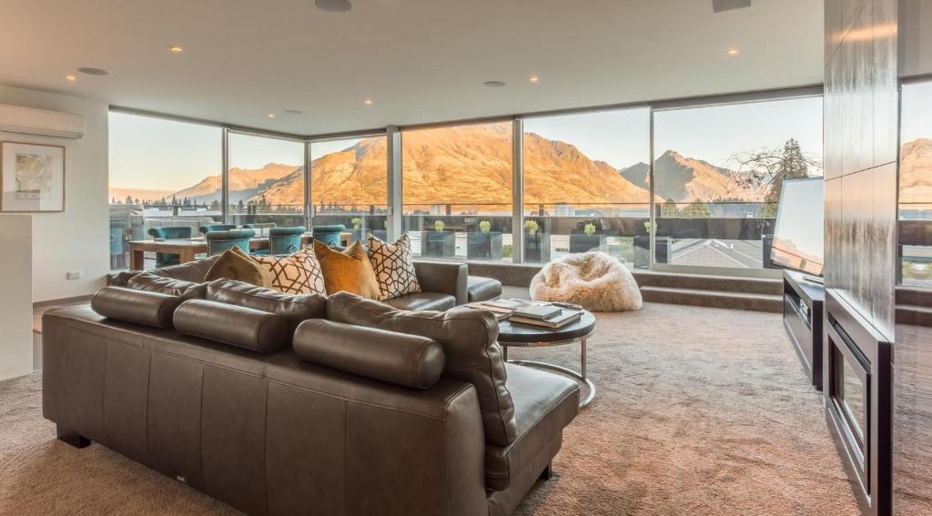 a living room with a couch and a large window at Views on Hallenstein in Queenstown