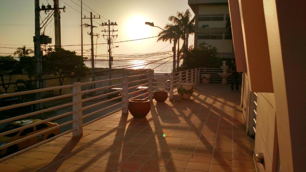 a balcony with the sun setting over the ocean at Hotel Bahia Plaza in Santa Marta