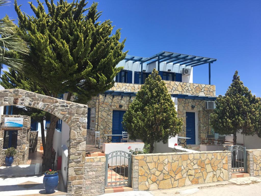 una casa con una valla de piedra y árboles en Serifos Palace en Livadakia