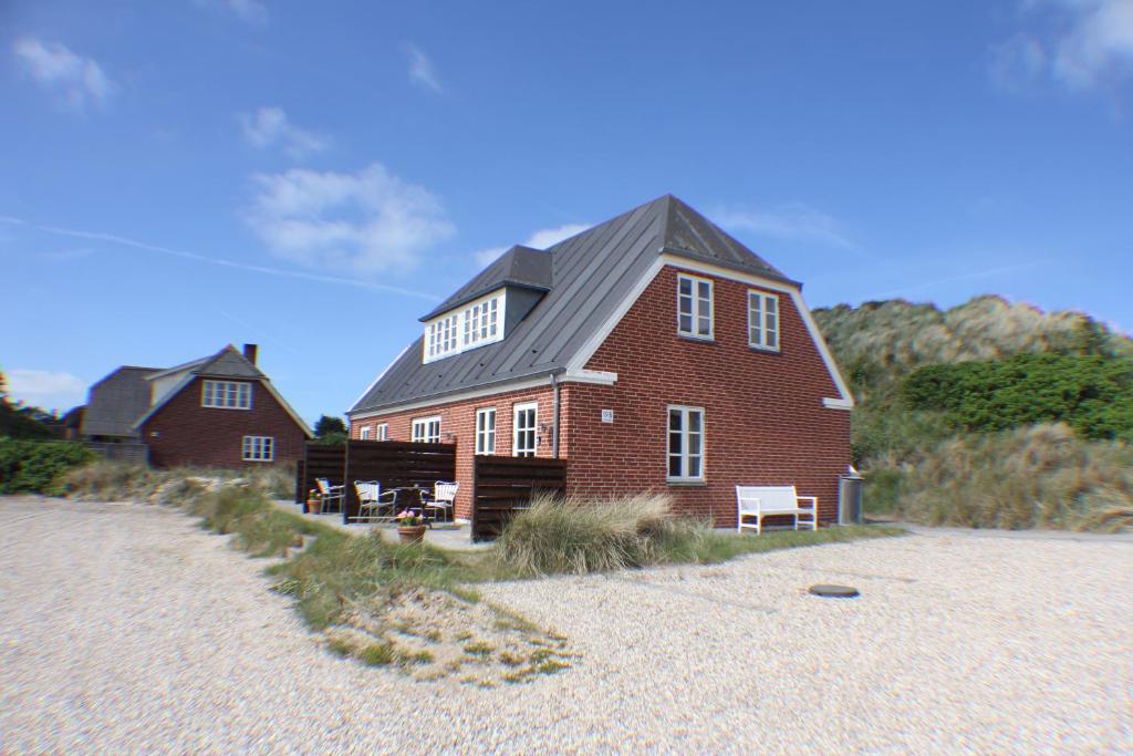 Klitgaarden Henne Strand في هين ستراند: منزل من الطوب الأحمر كبير على الشاطئ