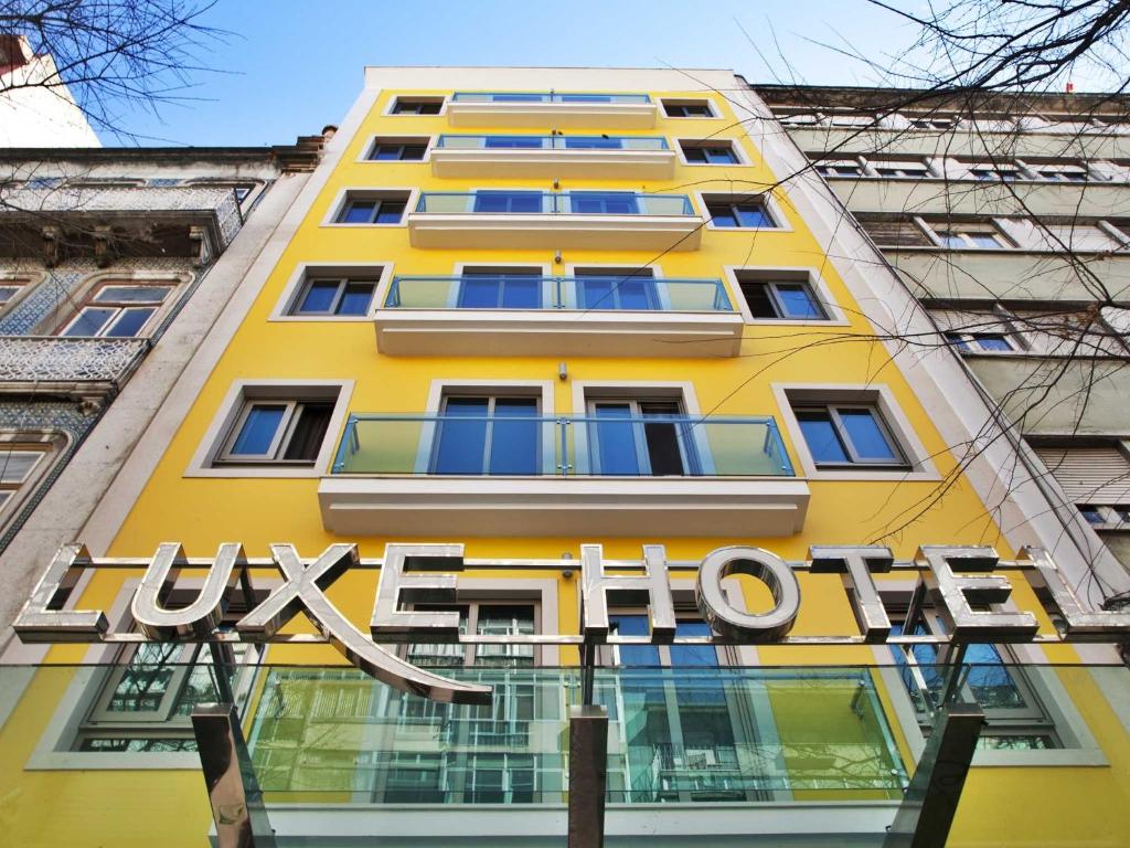 een geel gebouw met een bord aan de zijkant bij TURIM Luxe Hotel in Lissabon