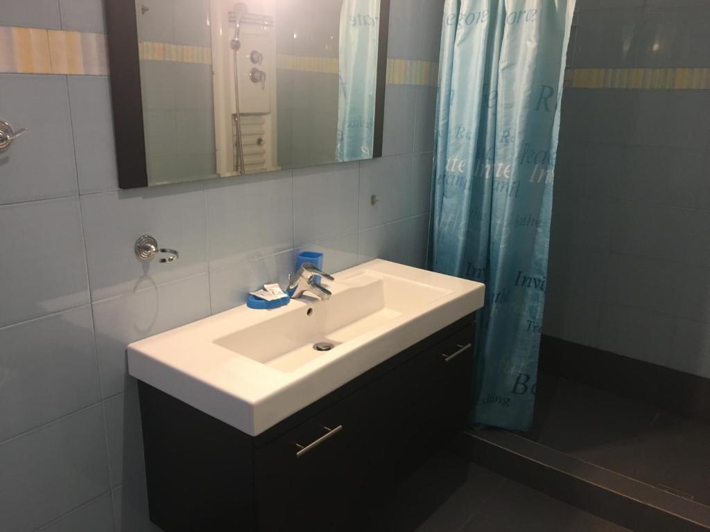 a bathroom with a white sink and a mirror at Serifos Palace in Livadakia