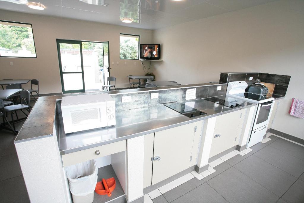 uma cozinha com armários brancos e uma bancada em Oamaru TOP 10 Holiday Park em Oamaru