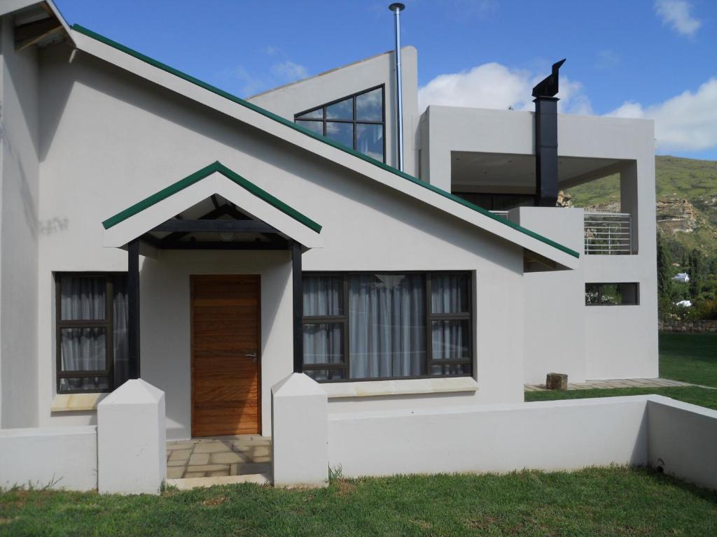 a white house with a brown door at Bella Vista Self Catering in Clarens