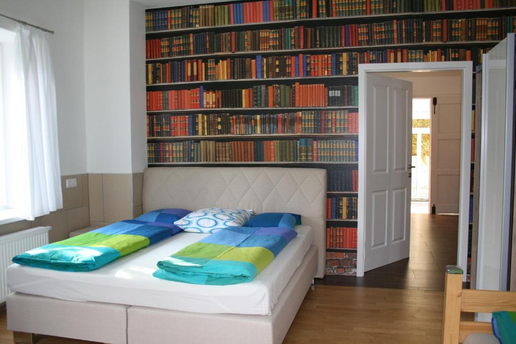 a bedroom with a bed in front of a wall of books at Gästehaus Egger in Emmersdorf an der Donau