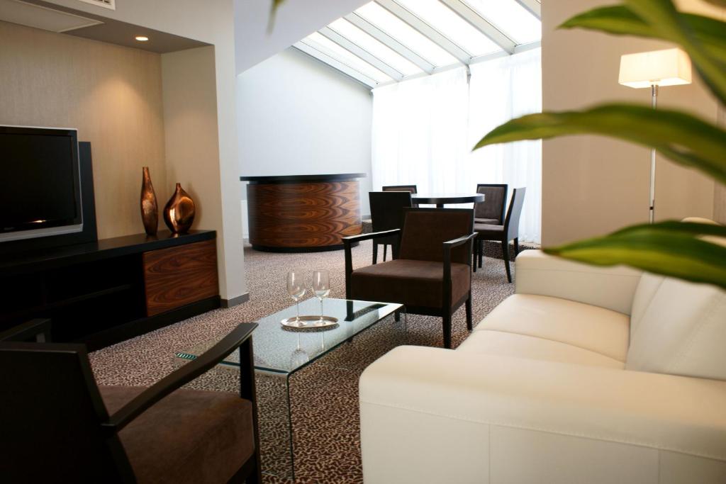 
a living room filled with furniture and a tv at Hotel Avance in Bratislava
