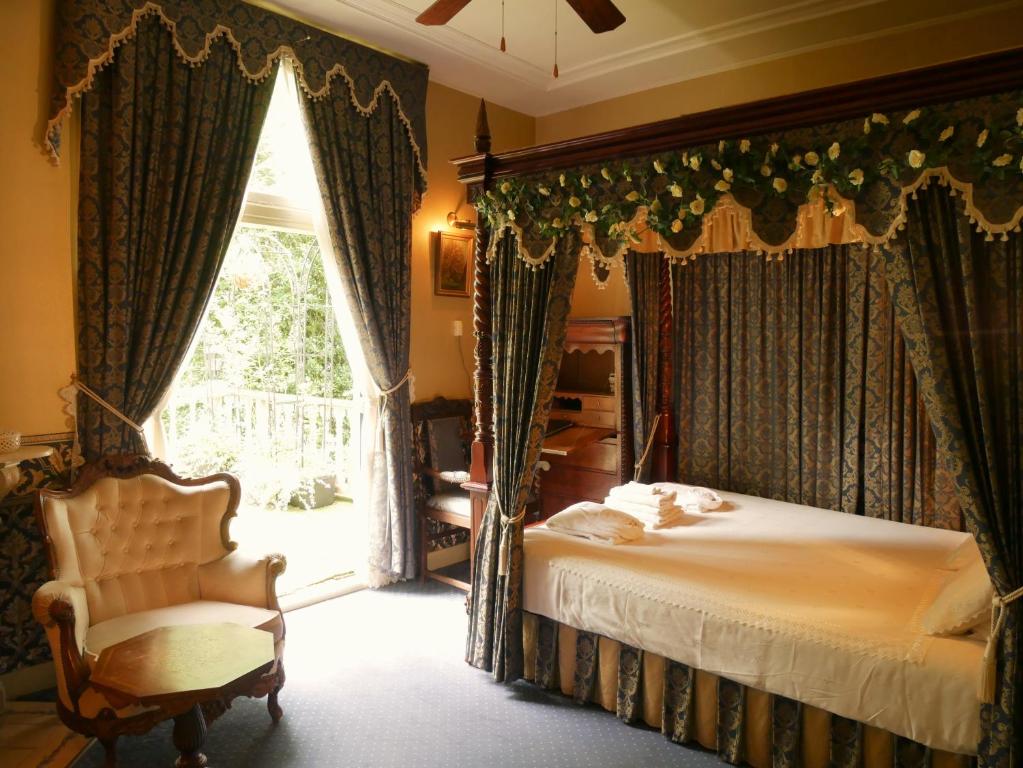 a bedroom with a bed and a chair and a window at Hotel Pegasus in Apeldoorn