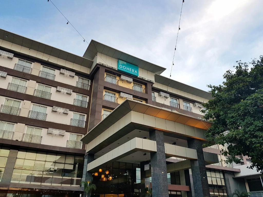 a large building with a sign on top of it at Dohera Hotel in Cebu City