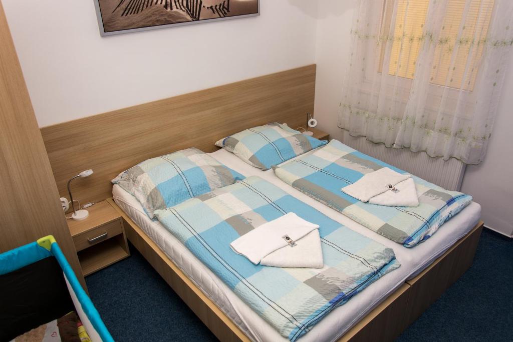 - une petite chambre avec 2 lits et une fenêtre dans l'établissement Penzion Harmonie, à Lednice