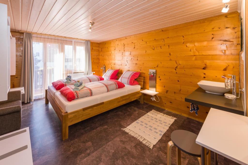 ein Schlafzimmer mit einem Bett in einer Holzwand in der Unterkunft apartment EFEU "mit stil & tradition" in Grächen