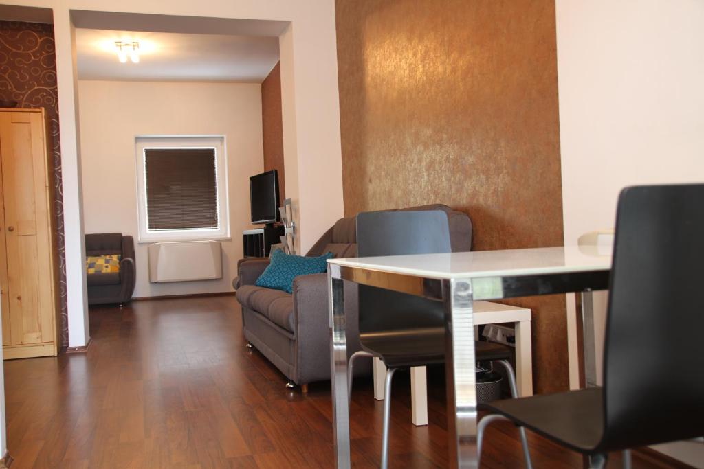 a living room with a table and a couch at Kukucinova Apartments in Bratislava