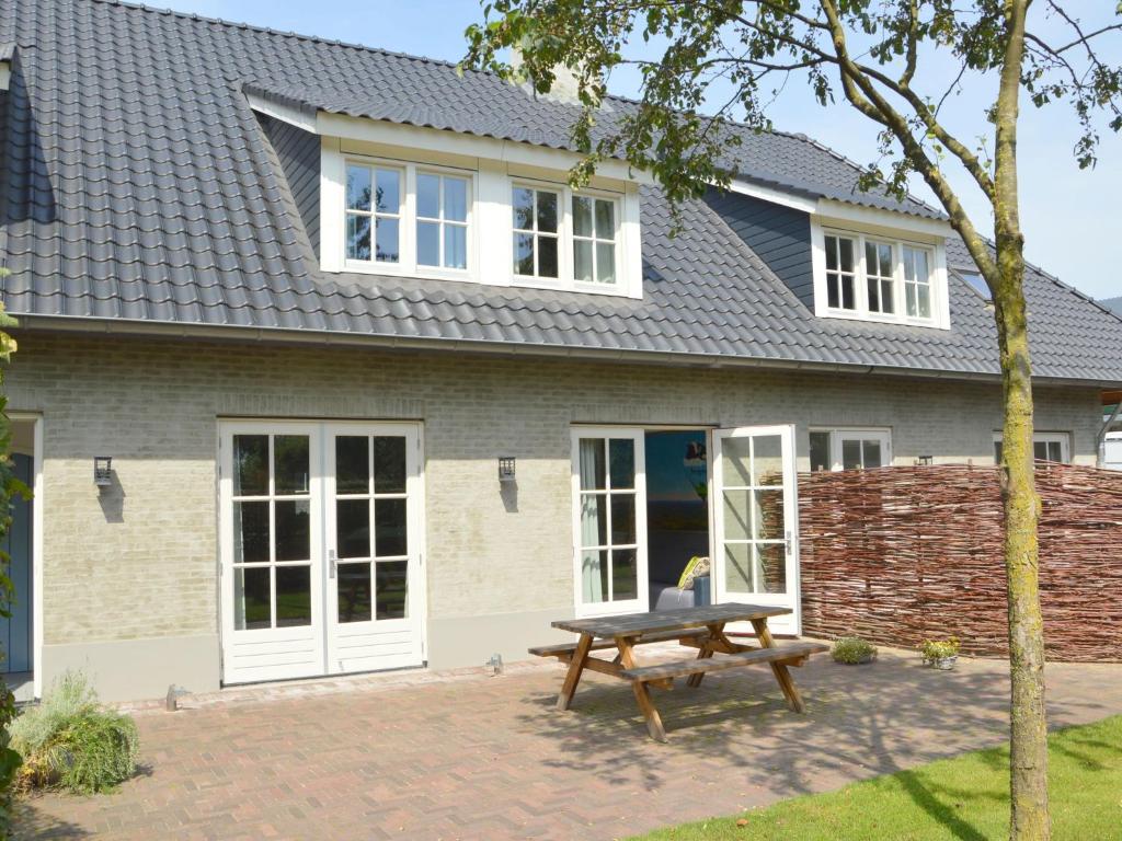 ein Haus mit einem Picknicktisch davor in der Unterkunft Holiday Home in Haaren near De Efteling in Haaren
