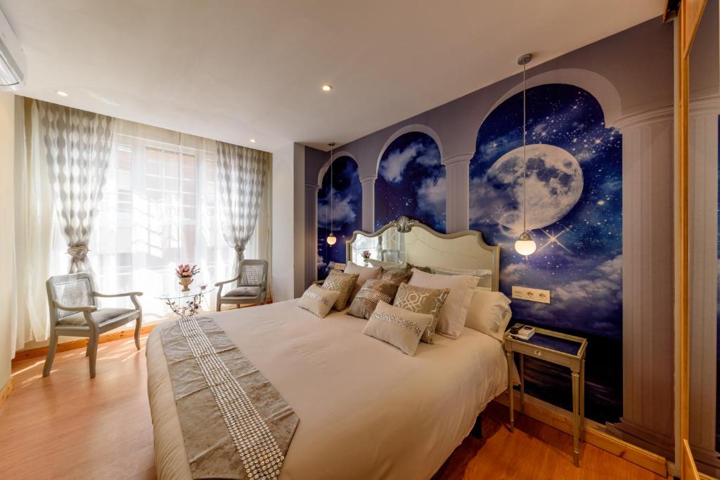 1 dormitorio con 1 cama grande y un mural de luna en Hosteria Villa de Castro, en Castro Urdiales