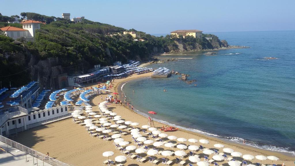 una playa con sombrillas y gente en la playa en La Limonaia, en Castiglioncello