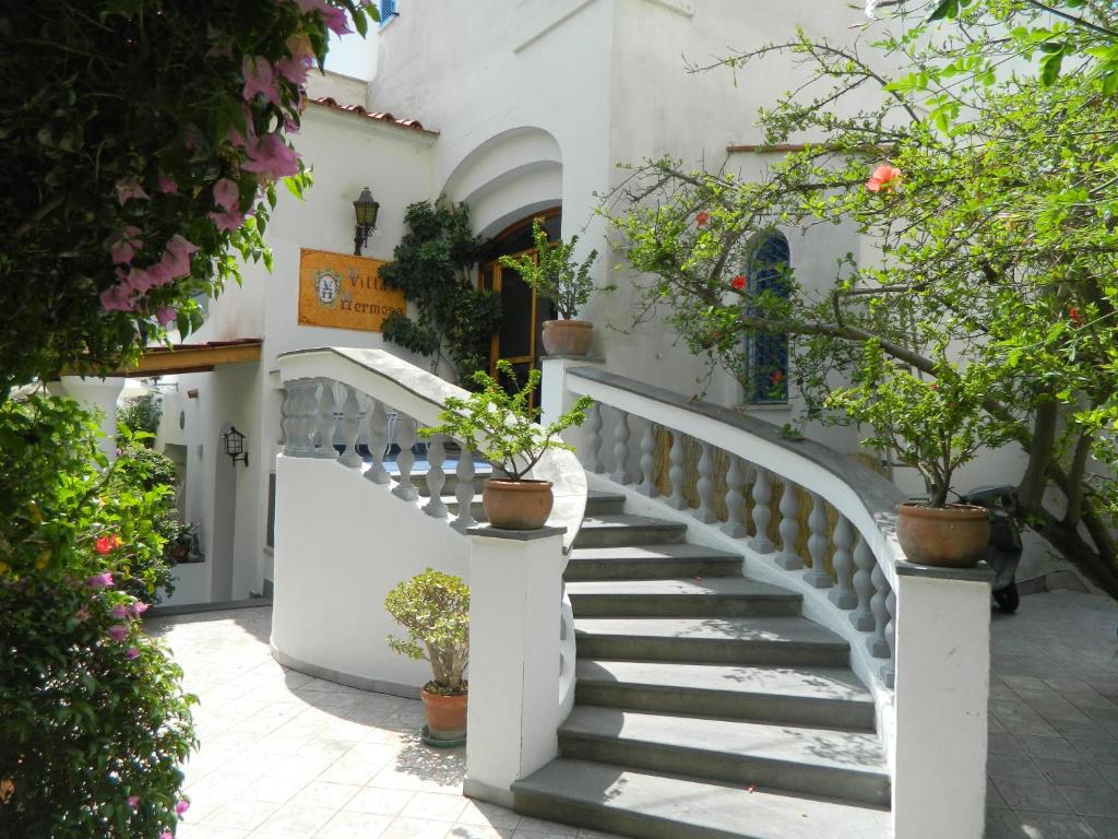 uma escadaria num edifício branco com vasos de plantas em Hotel Villa Hermosa em Ischia