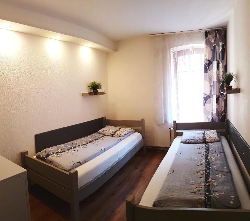 Habitación pequeña con cama y ventana en Hostel Orange, en Toruń