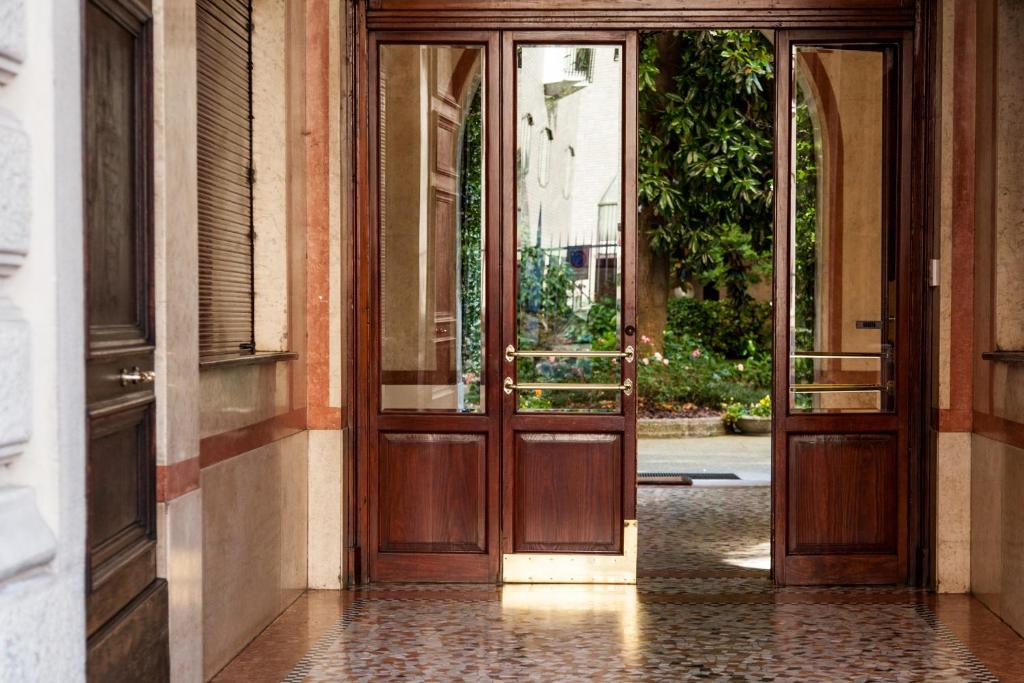 ミラノにあるHouse of Art Giovioの中庭付きの建物への開放木製ドア