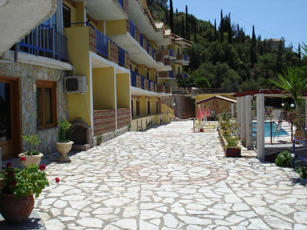 a courtyard of a building with a swimming pool at Politia Hotel in Agios Nikitas
