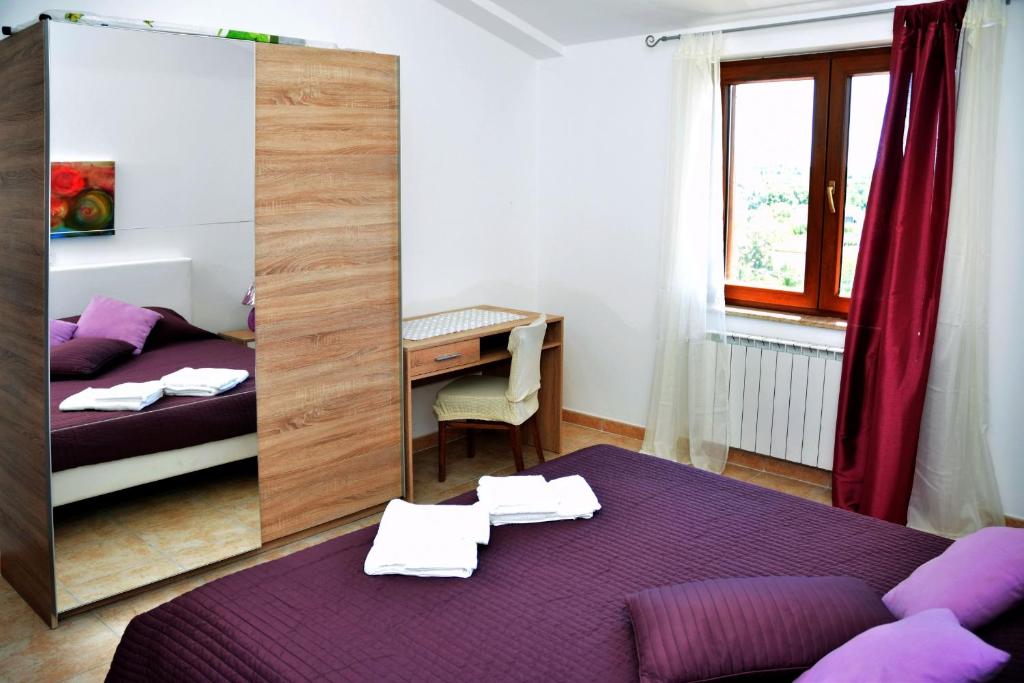 a bedroom with a purple bed and a desk at Sea view apartmant Nona with pool in Ližnjan