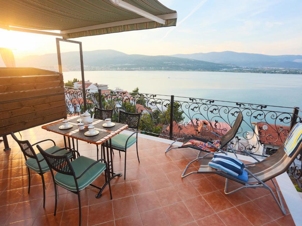 balcón con mesa, sillas y vistas al agua en Apartment Nanito, en Trogir