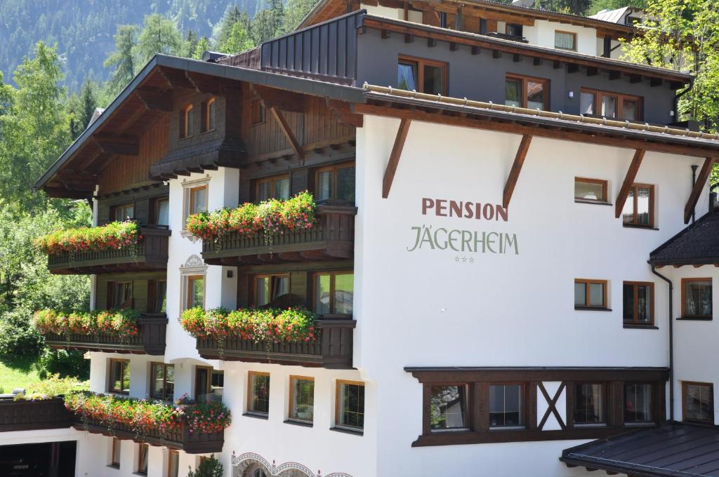 hotel w górach z kwiatami na balkonach w obiekcie Apart - und Frühstückspension Jägerheim w mieście Kaunertal