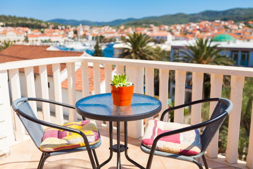 a table with two chairs and a potted plant on a balcony at Apartments Marija in Vela Luka