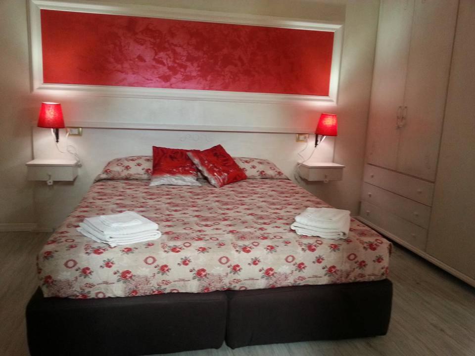 a bedroom with a bed with two red pillows at La Fontanella in Quartu SantʼElena