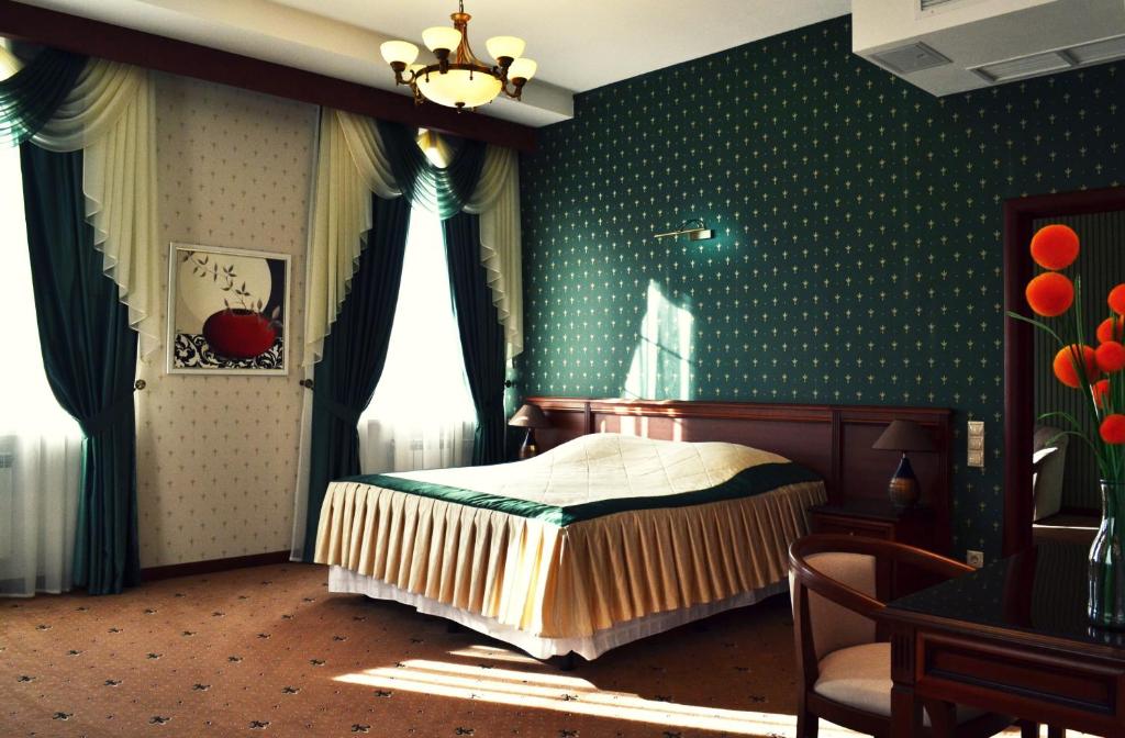 een slaapkamer met een bed en een groene muur bij Meridian in Saransk