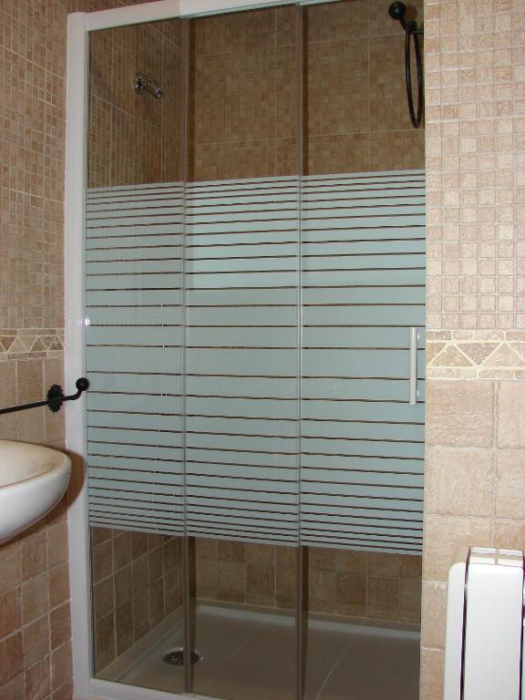 una ducha con puerta de cristal en un baño en Apartamentos Sierra de Segura, en Segura de la Sierra