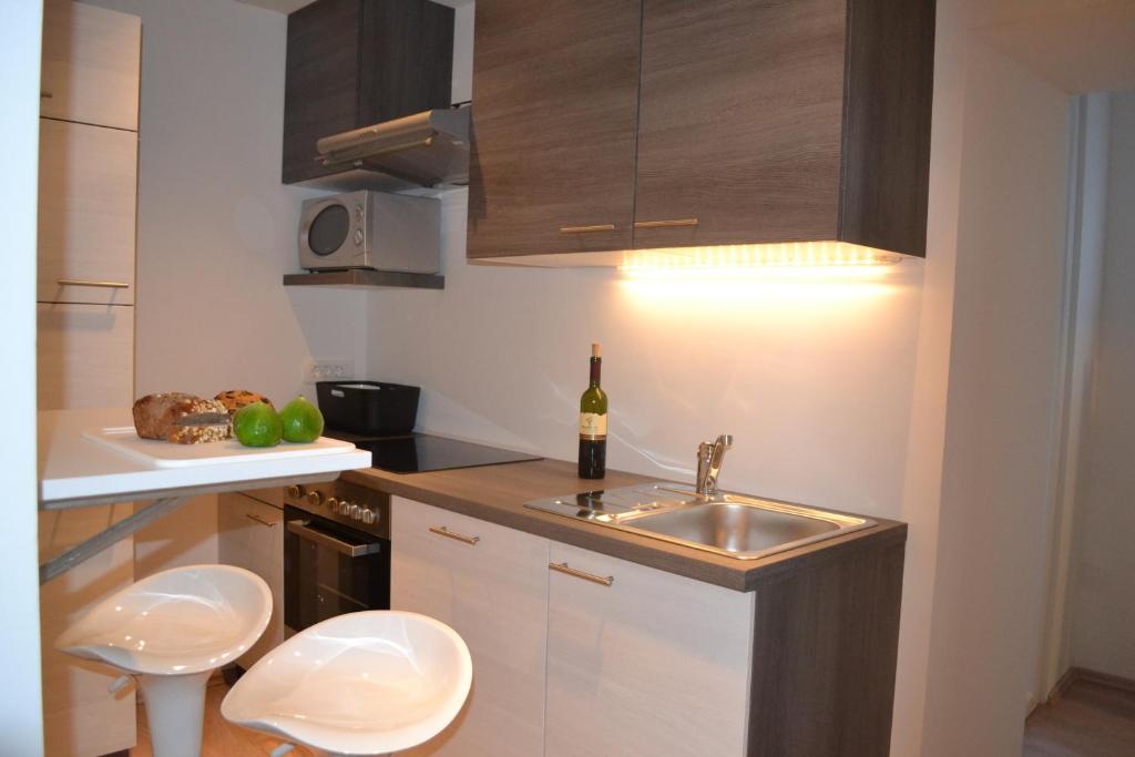 een keuken met een wastafel en een fles wijn bij Apartment Šik 1 in Koper