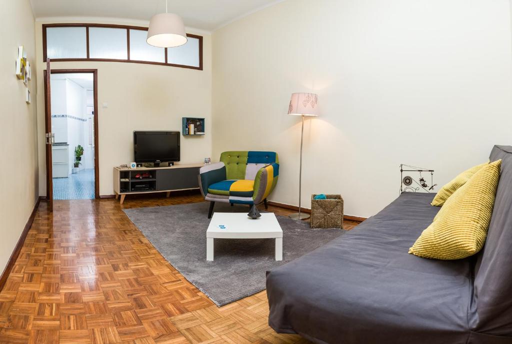 a living room with a couch and a chair at Downtown Shelter - Casa da Praça in Aveiro