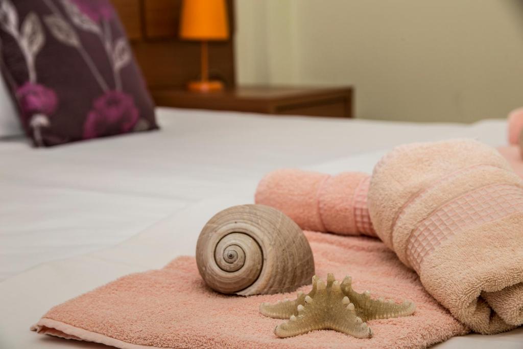 狄奧尼修海灘的住宿－帕克公寓，睡床上的毛绒毛上套的蜗牛