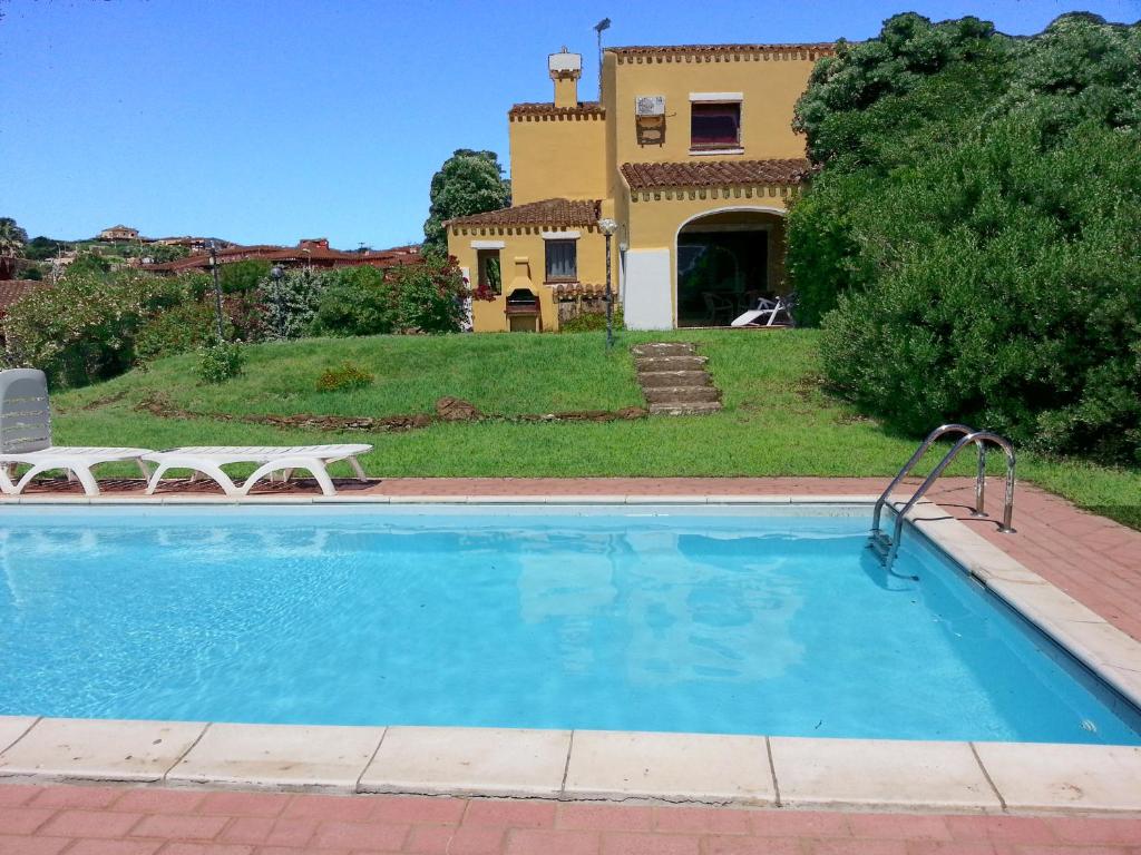 a swimming pool in front of a house at Villa Serena B in Stintino
