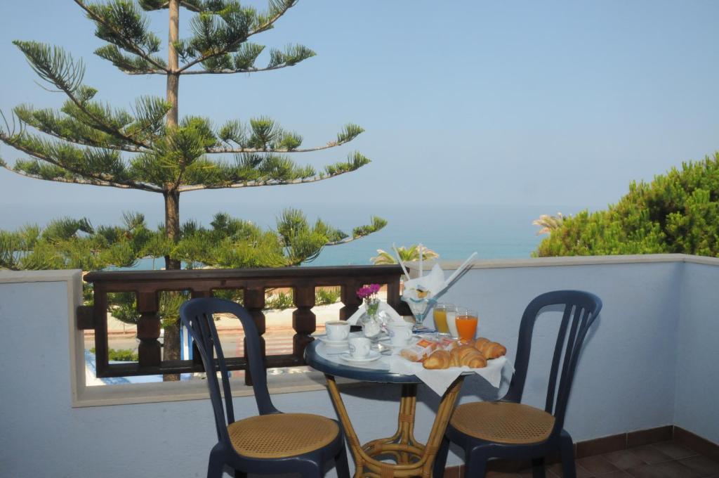 a table and chairs with a breakfast on the balcony at Beach Hotel in Diamante