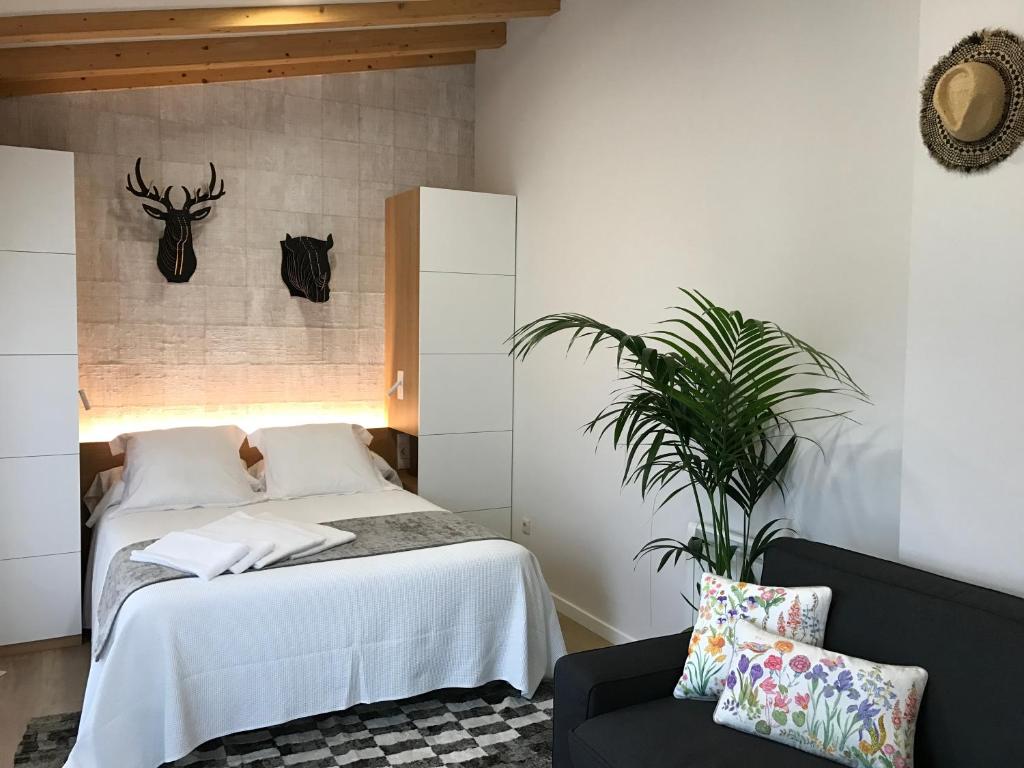 a bedroom with a bed and a chair and a plant at A Fonte das Hortas Residencial in Santiago de Compostela