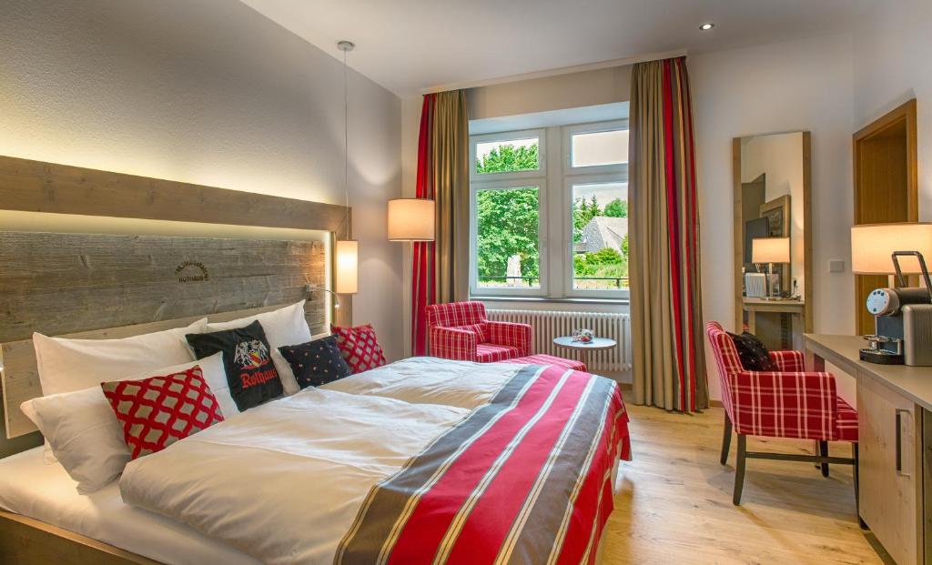 a bedroom with a large bed with red accents at Brauereigasthof Rothaus in Grafenhausen